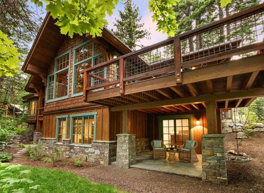 Experience rustic charm and modern comfort in this stunning mountain home, featuring a beautiful wood exterior complemented by stone accents.