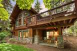 Experience rustic charm and modern comfort in this stunning mountain home, featuring a beautiful wood exterior complemented by stone accents.