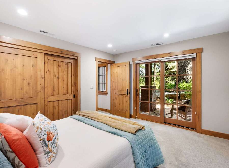 Experience rustic charm in this inviting bedroom featuring beautiful knotty pine sliding doors and a charming interior door.
