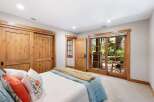 Experience rustic charm in this inviting bedroom featuring beautiful knotty pine sliding doors and a charming interior door.
