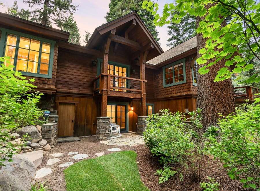 Nestled amidst towering trees, this stunning wooden home offers a rustic yet luxurious mountain retreat.