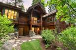Nestled amidst towering trees, this stunning wooden home offers a rustic yet luxurious mountain retreat.