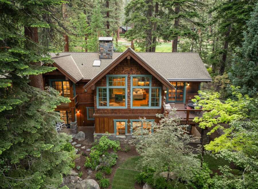 Nestled amidst a serene forest, this stunning timber-frame home offers a luxurious mountain retreat.