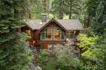 Nestled amidst a serene forest, this stunning timber-frame home offers a luxurious mountain retreat.
