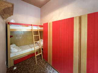 Discover this charming bedroom featuring a space-saving bunk bed with a convenient ladder, perfect for maximizing room utility.