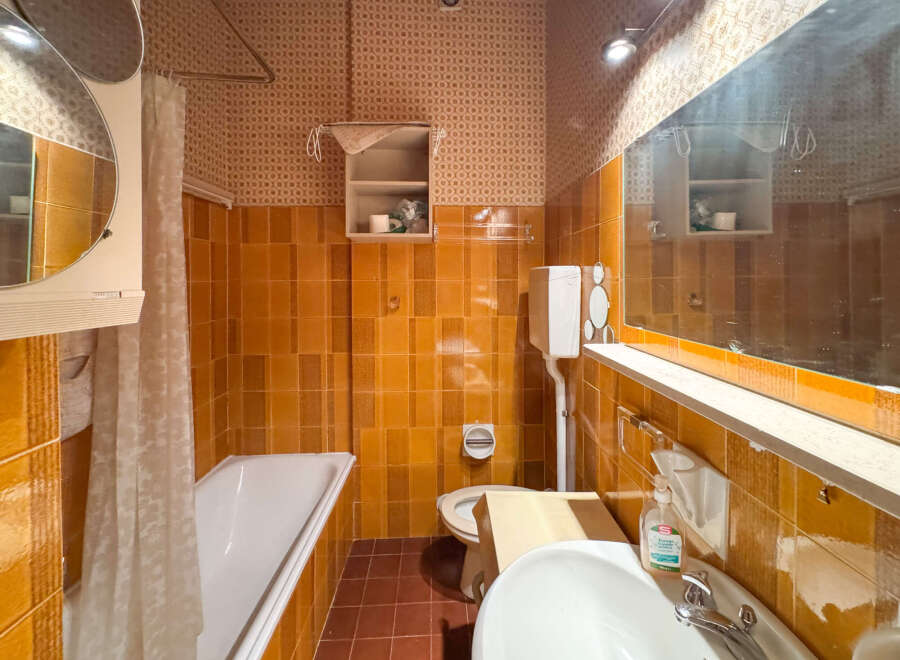This vintage bathroom features a classic clawfoot bathtub with a shower curtain, perfect for a relaxing soak.