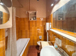 This vintage bathroom features a classic clawfoot bathtub with a shower curtain, perfect for a relaxing soak.
