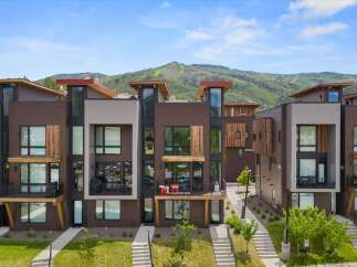 Experience modern mountain living in this stunning townhome, featuring a sleek, contemporary design with rich wood accents and expansive windows.