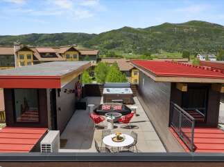 Experience luxury outdoor living with this stunning rooftop oasis, featuring a spacious hot tub perfect for relaxation and a modern fire pit area ideal for entertaining.
