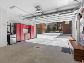 This spacious garage offers ample storage with bright red cabinets and a convenient workbench.