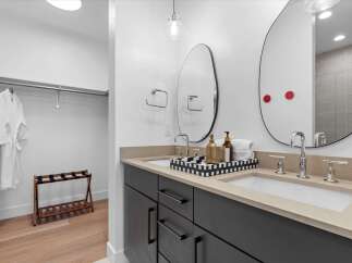 Experience luxury and convenience in this modern bathroom featuring a spacious dual vanity with sleek chrome fixtures and ample counter space.