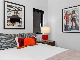 This stylish bedroom features a comfortable bed adorned with decorative pillows and a textured throw blanket.