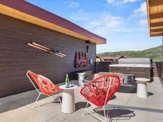 Enjoy breathtaking mountain views from this stunning rooftop patio, complete with a luxurious hot tub and comfortable seating.