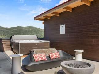 Experience ultimate relaxation on this stunning outdoor patio, complete with a luxurious hot tub and a modern fire pit.