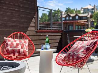Enjoy breathtaking mountain views from this stunning outdoor living space, complete with comfortable seating and a modern fire pit.