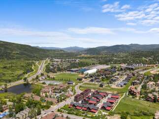 Discover this stunning aerial view of a vibrant community nestled amidst rolling hills and lush greenery.