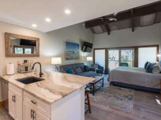 Experience comfortable living in this studio apartment featuring a well-equipped kitchenette with a granite countertop and modern sink.