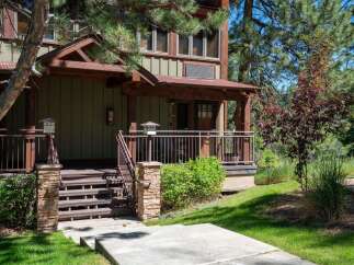 Charming mountain home featuring a rustic wooden exterior with a covered porch and stone accents.