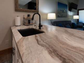 Experience luxury with this stunning kitchen island featuring a unique, marbled countertop that adds a touch of elegance to any home.