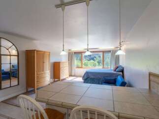 Experience comfortable living in this charming studio apartment, featuring a cozy bed and a bright, open living space.