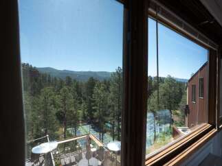 Enjoy breathtaking mountain views from this stunning property, featuring a private tennis court nestled amongst lush pine trees.