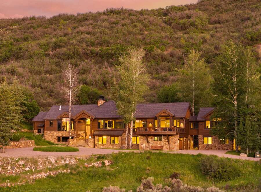Experience luxury mountain living in this stunning custom-built home, nestled against a picturesque hillside.