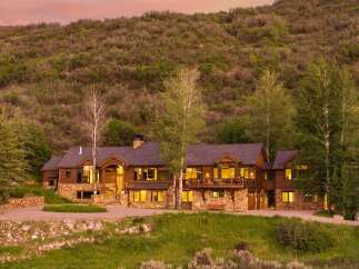 Experience luxury mountain living in this stunning custom-built home, nestled against a picturesque hillside.