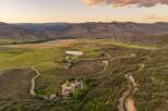 Experience breathtaking mountain vistas from this expansive estate, featuring a main residence with solar panels and a charming guest house.