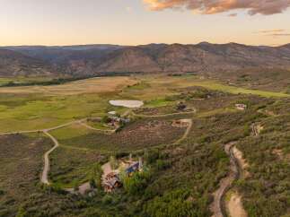 Experience breathtaking mountain vistas from this expansive estate, featuring a main residence with solar panels and a charming guest house.