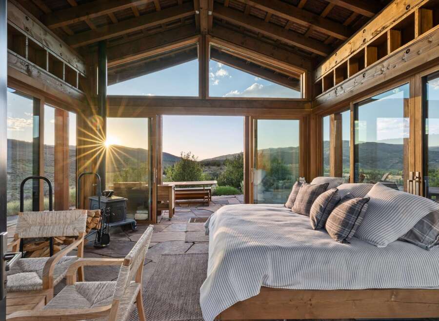 Experience breathtaking sunset views from this stunning bedroom, featuring expansive floor-to-ceiling windows that seamlessly blend indoor and outdoor living.