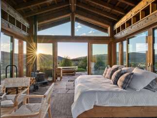 Experience breathtaking sunset views from this stunning bedroom, featuring expansive floor-to-ceiling windows that seamlessly blend indoor and outdoor living.