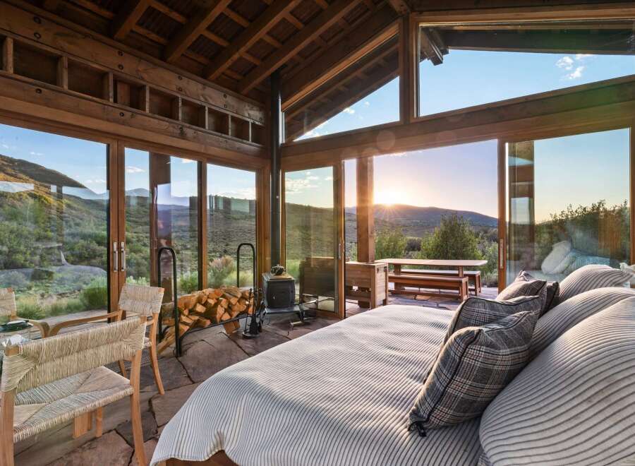 Experience breathtaking sunset views from this stunning mountain retreat, featuring expansive floor-to-ceiling windows that seamlessly blend indoor and outdoor living.