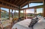 Experience breathtaking sunset views from this stunning mountain retreat, featuring expansive floor-to-ceiling windows that seamlessly blend indoor and outdoor living.