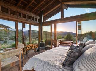 Experience breathtaking sunset views from this stunning mountain retreat, featuring expansive floor-to-ceiling windows that seamlessly blend indoor and outdoor living.