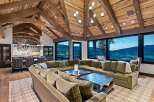 Experience luxury mountain living in this stunning home featuring a grand living room with a massive sectional sofa and a rustic vaulted ceiling with exposed wooden beams.