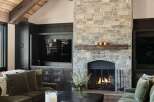 Experience rustic elegance in this living room, featuring a grand stone fireplace with a reclaimed wood mantel, perfect for cozy evenings.