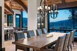 Experience luxurious mountain living in this stunning dining room, featuring a grand wooden table and plush seating perfect for hosting.