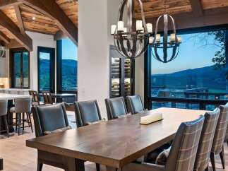 Experience luxurious mountain living in this stunning dining room, featuring a grand wooden table and plush seating perfect for hosting.