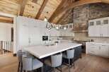 Experience luxury mountain living in this stunning kitchen, featuring a grand island with waterfall countertops and comfortable bar seating.