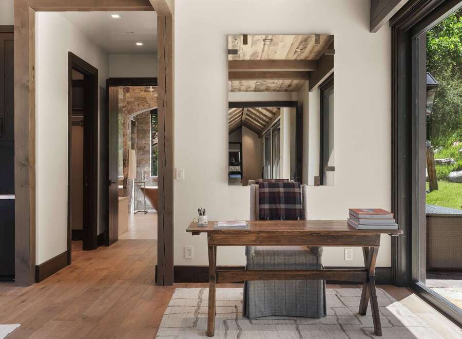Discover this inviting home office space featuring a rustic wooden desk and chair, perfect for focused work.