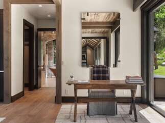 Discover this inviting home office space featuring a rustic wooden desk and chair, perfect for focused work.