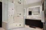 Experience luxury in this stunning bathroom featuring a spacious glass-enclosed shower with multiple showerheads and a built-in bench.
