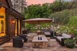 Experience outdoor living at its finest with this luxurious patio featuring a modern fire pit and a relaxing hot tub.