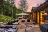 Experience luxurious outdoor living with this stunning patio featuring a bubbling hot tub, a built-in grill, and a cozy fire pit.
