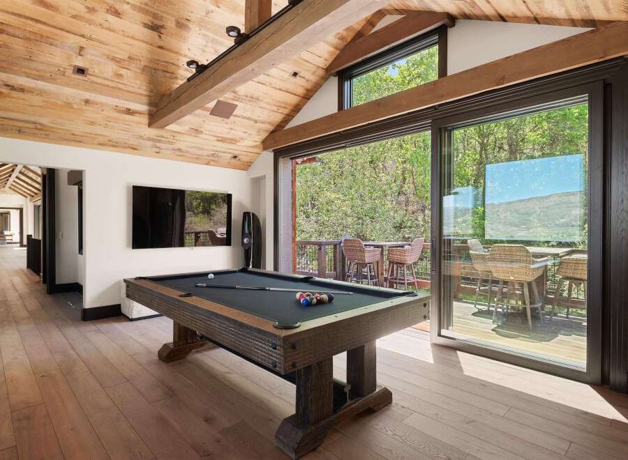 Experience ultimate relaxation and entertainment in this stunning game room, featuring a professional-grade pool table and a large flat-screen TV.