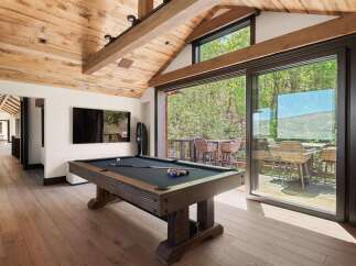 Experience ultimate relaxation and entertainment in this stunning game room, featuring a professional-grade pool table and a large flat-screen TV.