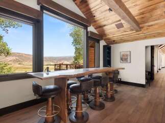 Experience breathtaking mountain views from this stunning live-edge bar, perfect for entertaining guests.