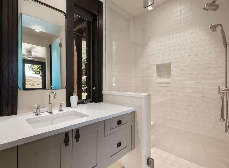 Experience modern luxury in this stunning bathroom featuring a sleek vanity with a undermount sink and brushed nickel fixtures.