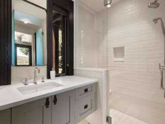 Experience modern luxury in this stunning bathroom featuring a sleek vanity with a undermount sink and brushed nickel fixtures.