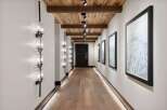 Experience luxury mountain living in this stunning hallway featuring a rustic wood-planked ceiling with exposed beams and modern track lighting.